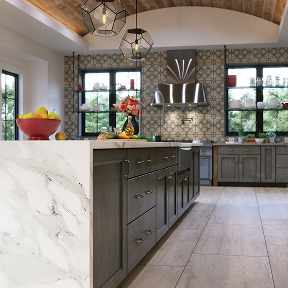 Kitchen with large island. Porcealin tile floors, mosaic tile backsplash, and quartz countertops in a modern farmhouse.